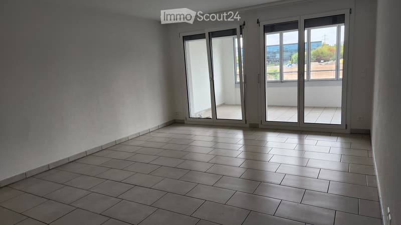Empty room with tiled floor and large sliding glass doors leading to a balcony area.