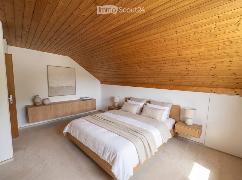 Modern bedroom with a wooden slanted ceiling, a large bed with white linens, nightstands with lamps, a wooden cabinet with vases, and a picture frame on the wall.