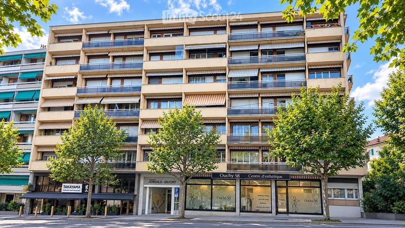 Multi-story residential building with balconies, awnings, and storefronts at the ground level, including a restaurant and a beauty center.