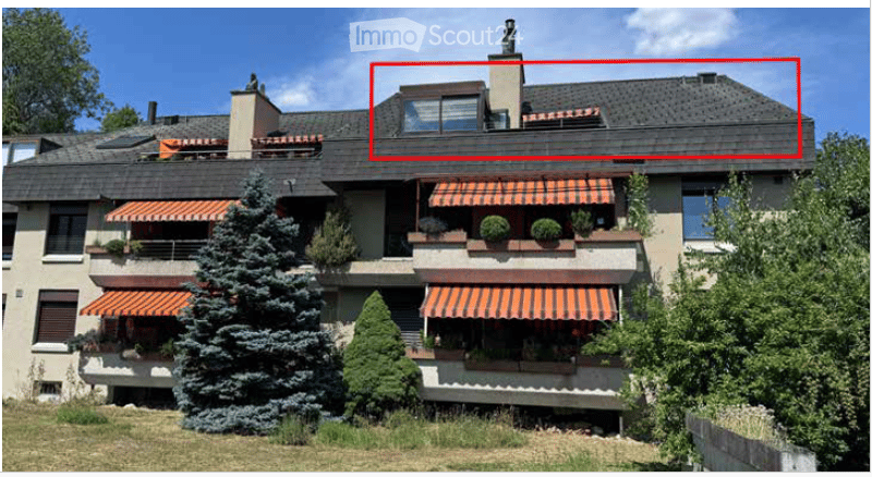 Multi-story residential house with multiple balconies, large windows, and a prominent roof with dormer windows. The building features orange striped awnings and is surrounded by greenery.