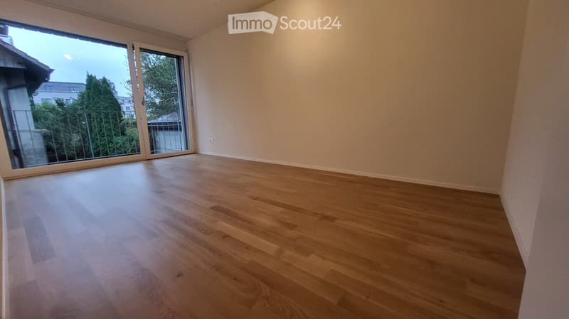 wooden floor, sliding glass doors to balcony, white walls, no furniture