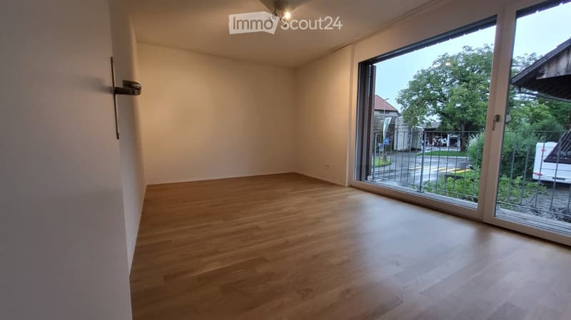 empty room, hardwood floor, glass sliding doors, metal railings, tree view