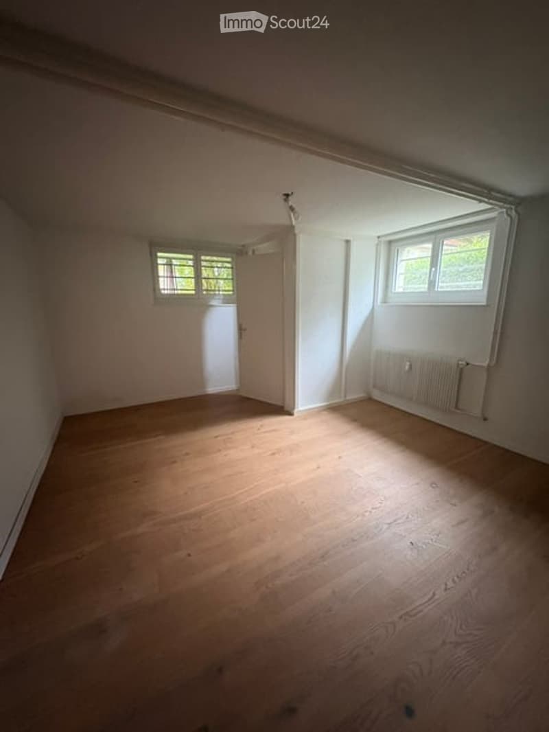 Empty room with wooden flooring, white walls, and two windows. No furniture or equipment present.