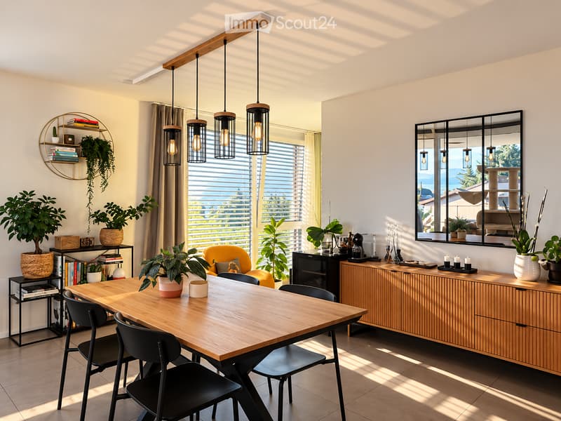 Bright and airy dining area with a wooden table, black chairs, pendant lights, and a large window with blinds. The space features a wooden cabinet, potted plants, and a decorative shelf with books and a plant.