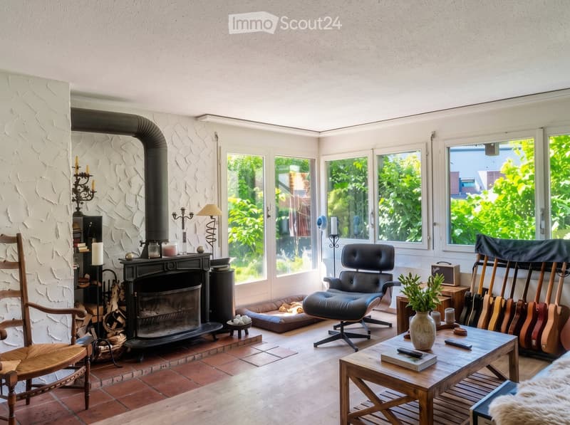 {"visible_features": ["Fireplace"], "type": "Living Room", "objects": ["wooden chair", "leather armchair", "coffee table", "guitar", "vase", "candle holder", "table lamp", "guitar stand", "guitar", "guitar", "guitar", "guitar", "guitar", "guitar", "guitar