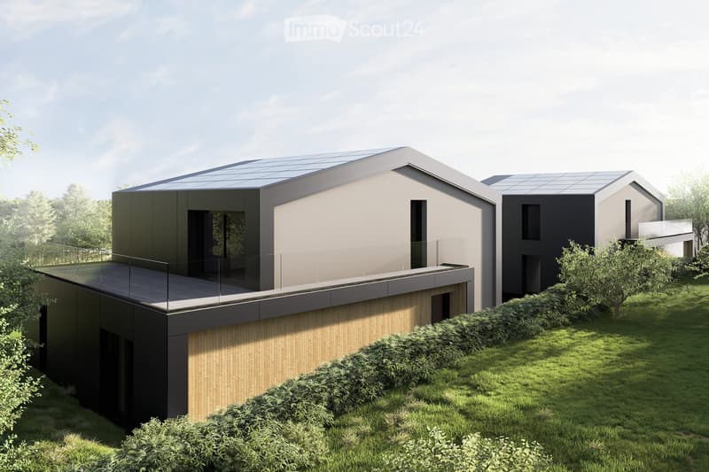 Modern two-story house with a flat roof, solar panels, large windows, and a glass balcony on the upper level. The house is surrounded by a well-maintained lawn and shrubs.