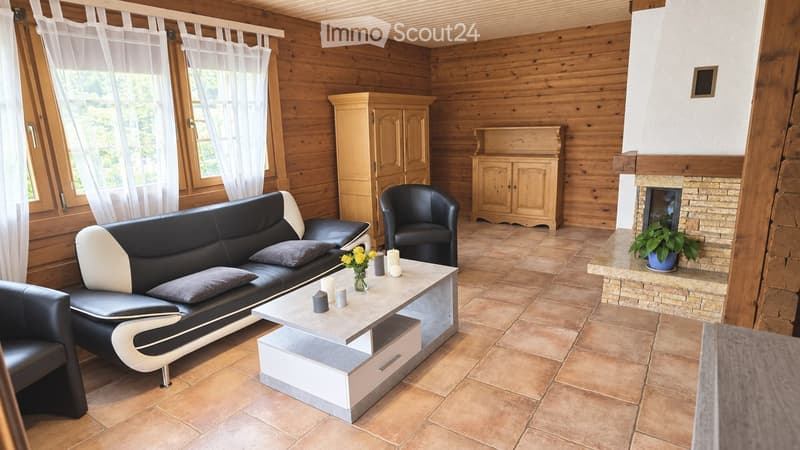 Cozy living room with wooden walls, tiled floor, fireplace, sofa, coffee table, armchair, and decorative candles.