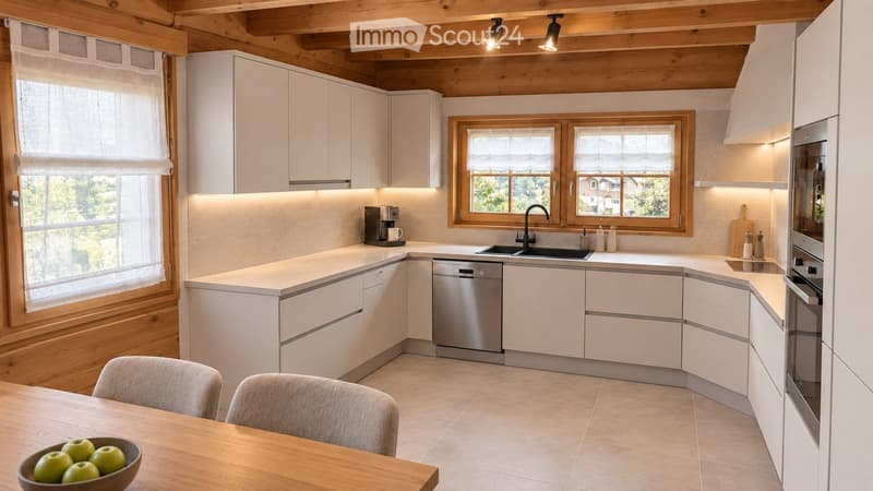 Modern kitchen with white cabinets, wooden beams, and stainless steel appliances. Features a central island, a dining area with a wooden table and chairs, and a window overlooking a green landscape.