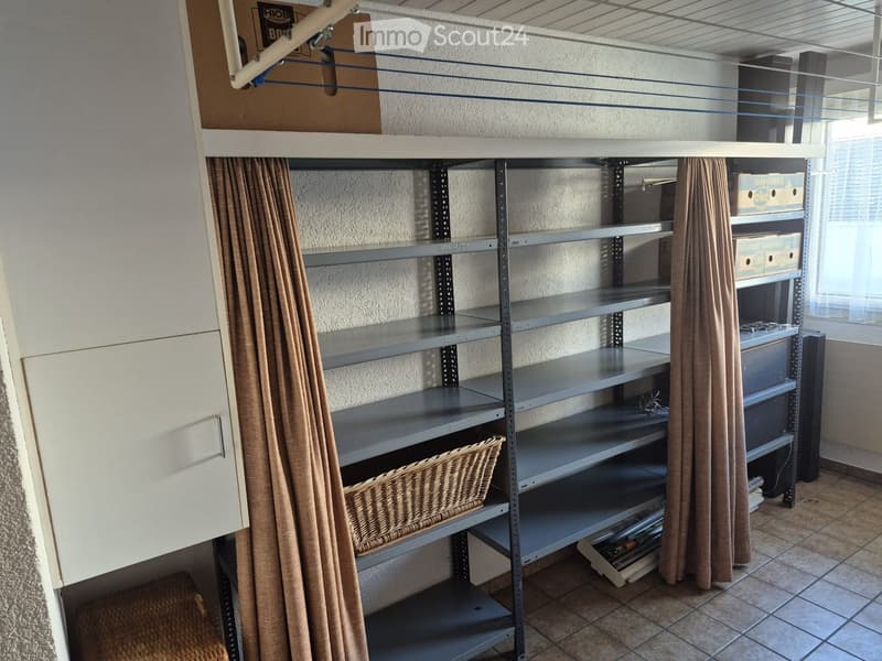 Empty storage room with metal shelving units, a wicker basket, and a few boxes on the shelves.