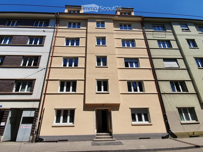 5 story building, beige exterior, white windows, entrance with stairs, number 7