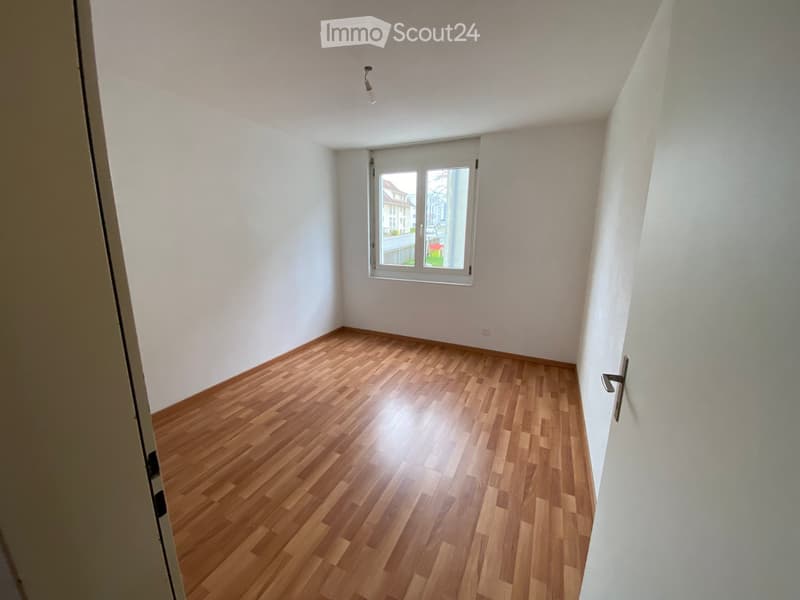 Empty room with wooden flooring, white walls, and a window with blinds. No furniture or equipment present.