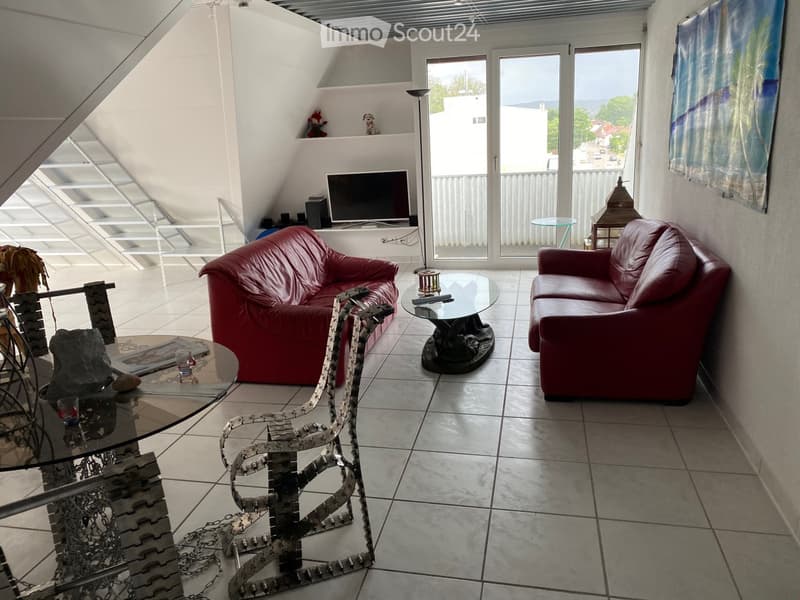 {"visible_features": ["Balcony / Terrace"],"type": "Living room","description": "Spacious living room with large windows, red leather sofa and armchair, glass coffee table, TV stand, and decorative items on shelves. The room has a tiled floor and opens