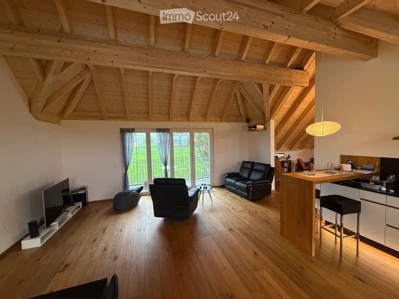 Wohnzimmer mit blick auf Balkon und unbebaute Wiese/Berge