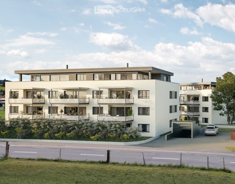 Modern two-story residential building with white facade, large windows, balconies, and a garage entrance.