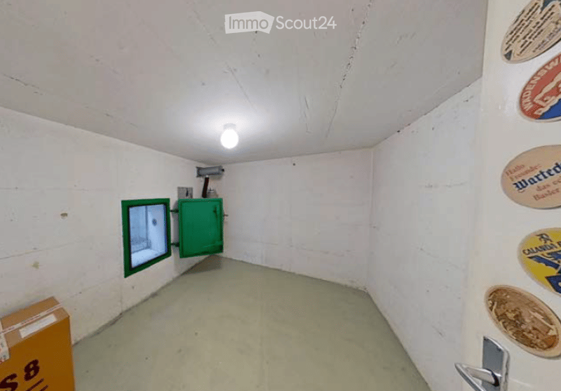 Empty room with white walls, a green cabinet, a small window, and a light fixture on the ceiling.