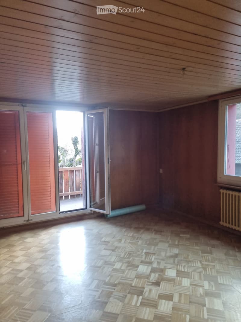 Empty room with wooden wall, wooden parquet floor, balcony with outdoor railings