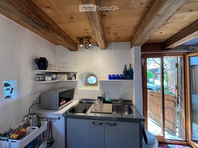 kitchen with a small sink, microwave, dishwasher, kitchen shelves, wooden cabinets, wooden ceiling