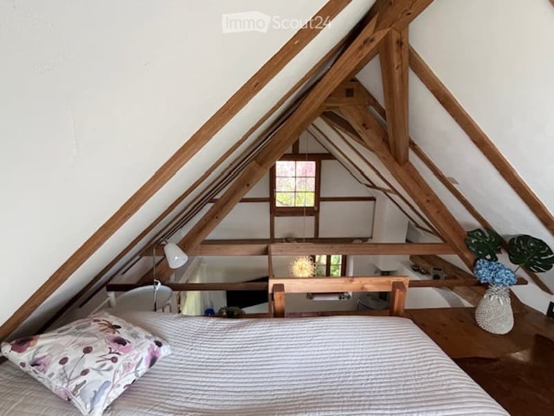 wooden bed, decorative pillow, white bedspread, wooden beams, balcony, windows, lamps, decorative plants