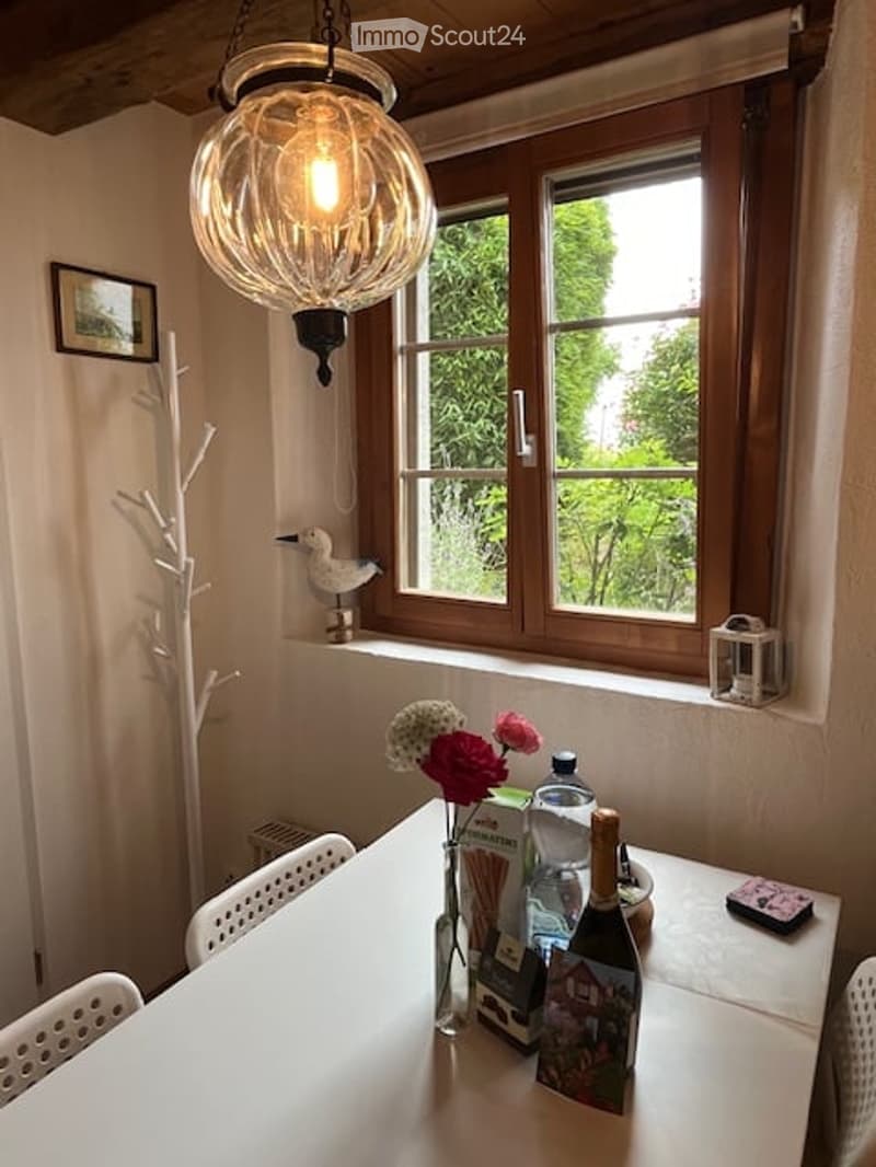 dining area with table, chairs, view of the garden, flowers, white walls