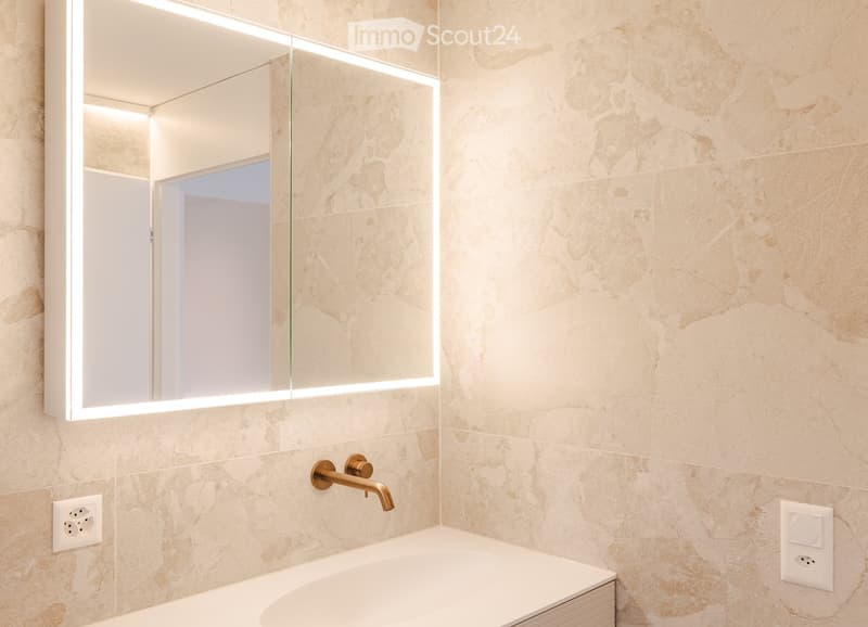 Modern bathroom with a large illuminated mirror, a sleek bathtub, and a stylish brass faucet.