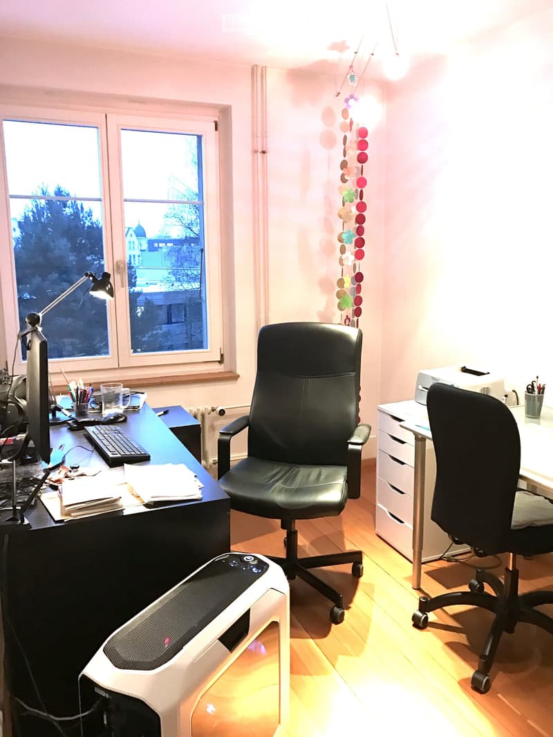 modern office with black leather chairs, desk, computer, lamp, paper, books, radiator, and office supplies