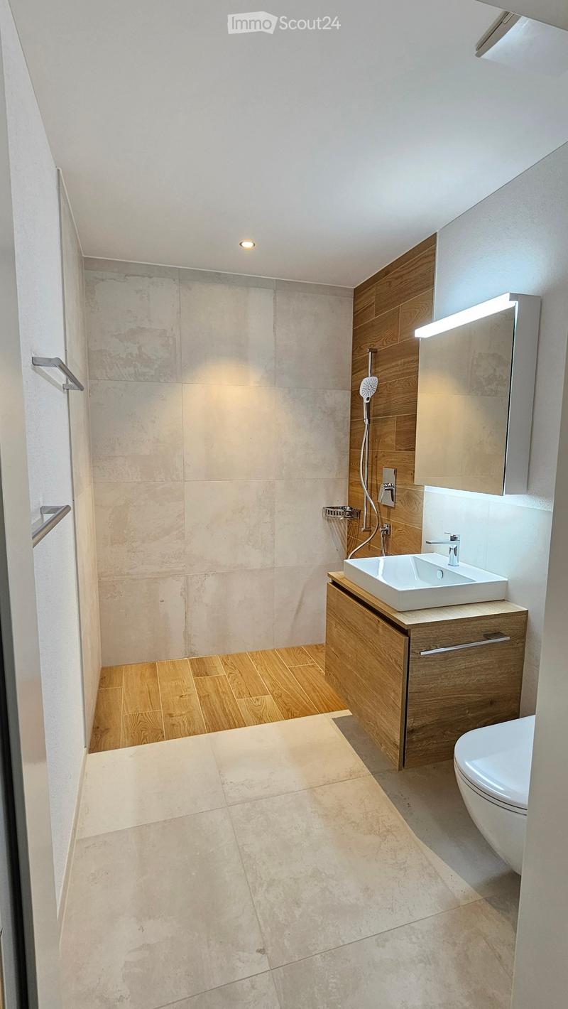 modern bathroom with shower, toilet, wooden vanity and underfloor heating