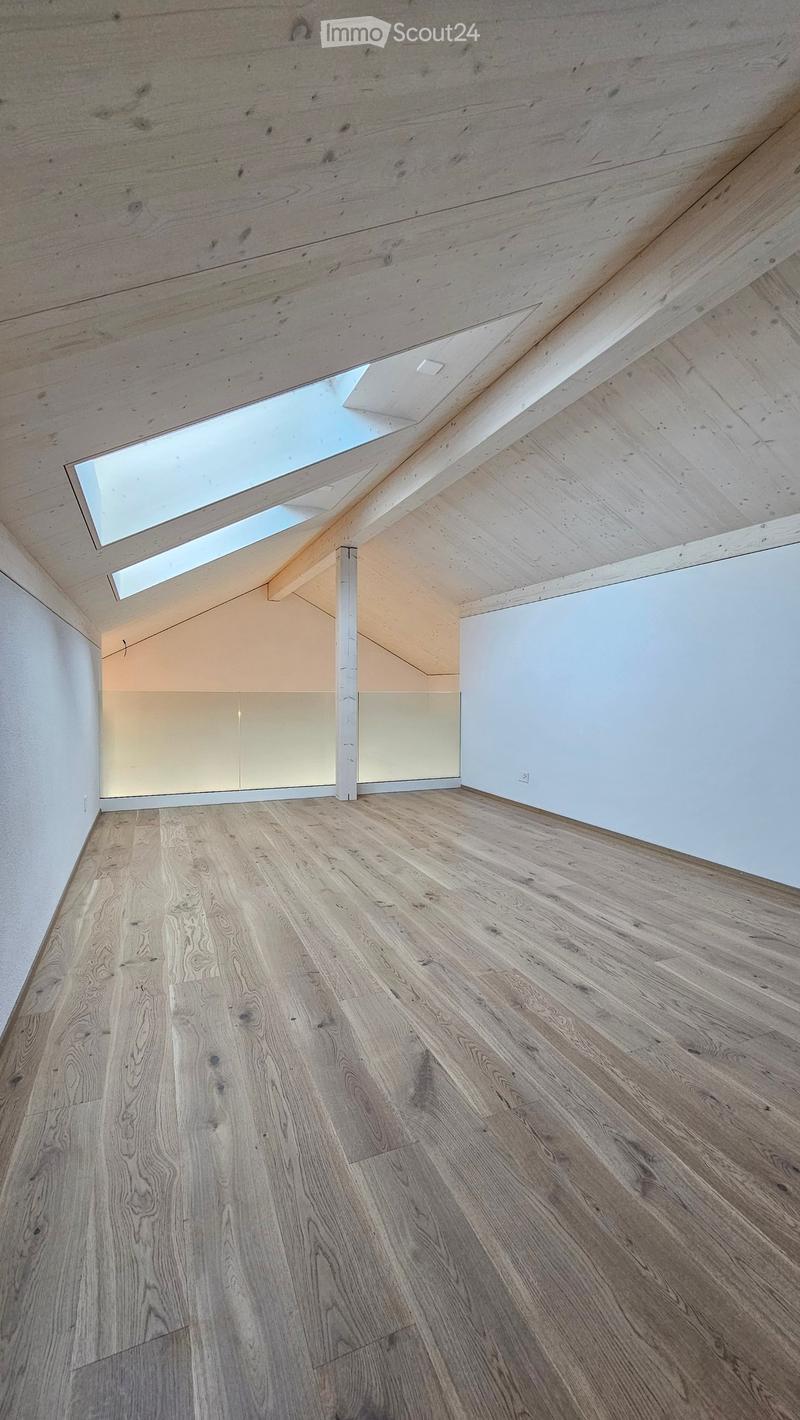 room with hardwood floors, skylit ceiling, white walls, and a skylight