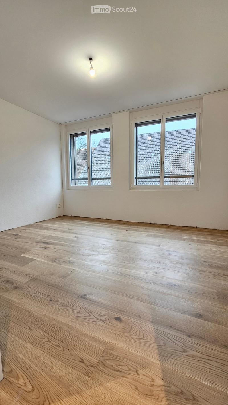 Empty room, hardwood floors, two large windows, recessed ceiling light