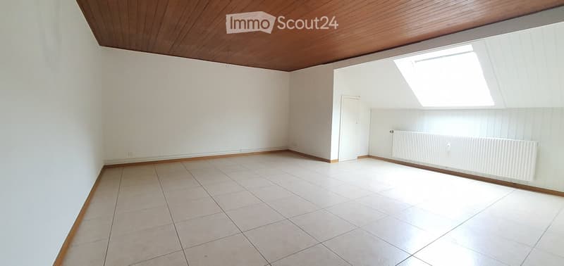 Empty room with white tiled floor, white walls, wooden trim, and a skylight window. No furniture or equipment present.