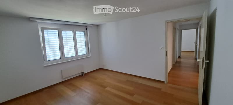 Empty room with wooden flooring, white walls, and a window with blinds. No furniture or equipment is present.
