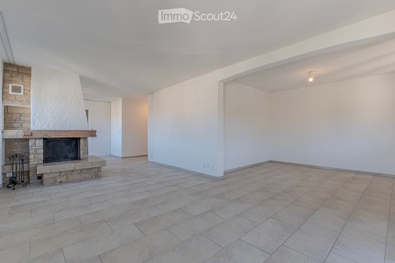 Empty room with tiled floor, white walls, and a stone fireplace with a black insert. No furniture or equipment present.