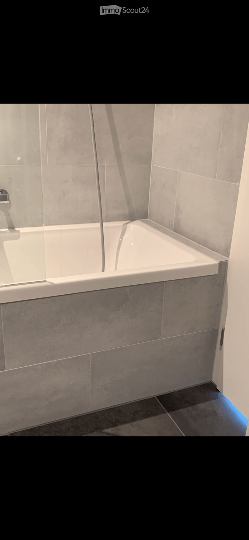 modern built-in bathtub, shower head, grey tiles, shower hose