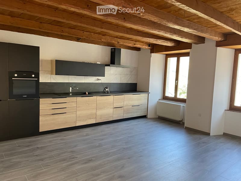 Modern kitchen with wooden cabinets, stainless steel appliances, and a wooden ceiling. Features include a sink, faucet, oven, and radiator.