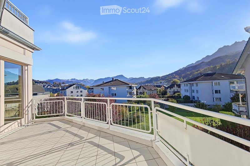 Balcony with white tiled flooring, white metal railing, and scenic mountain view in the background.