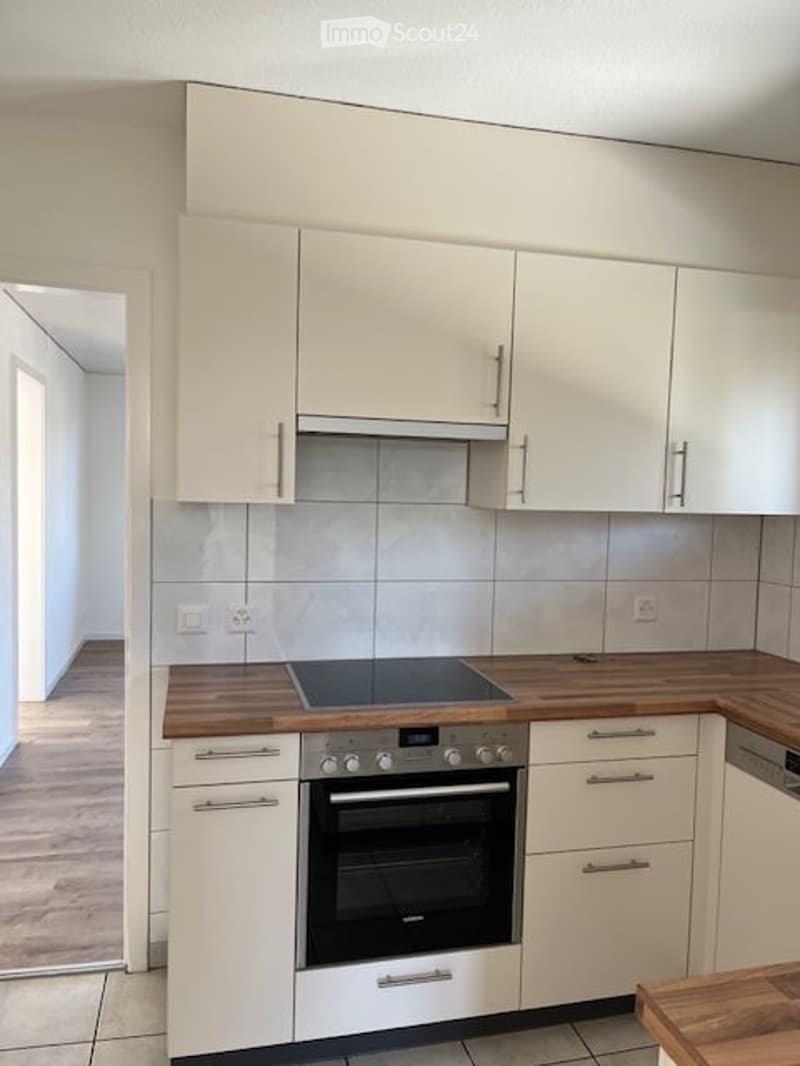 kitchen with built-in oven, dishwasher, and white cabinets