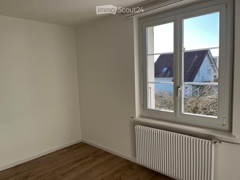 empty room, white walls, wooden floor, white window, white radiator