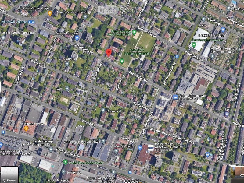 Aerial view of a residential area with multiple buildings, streets, and green spaces.