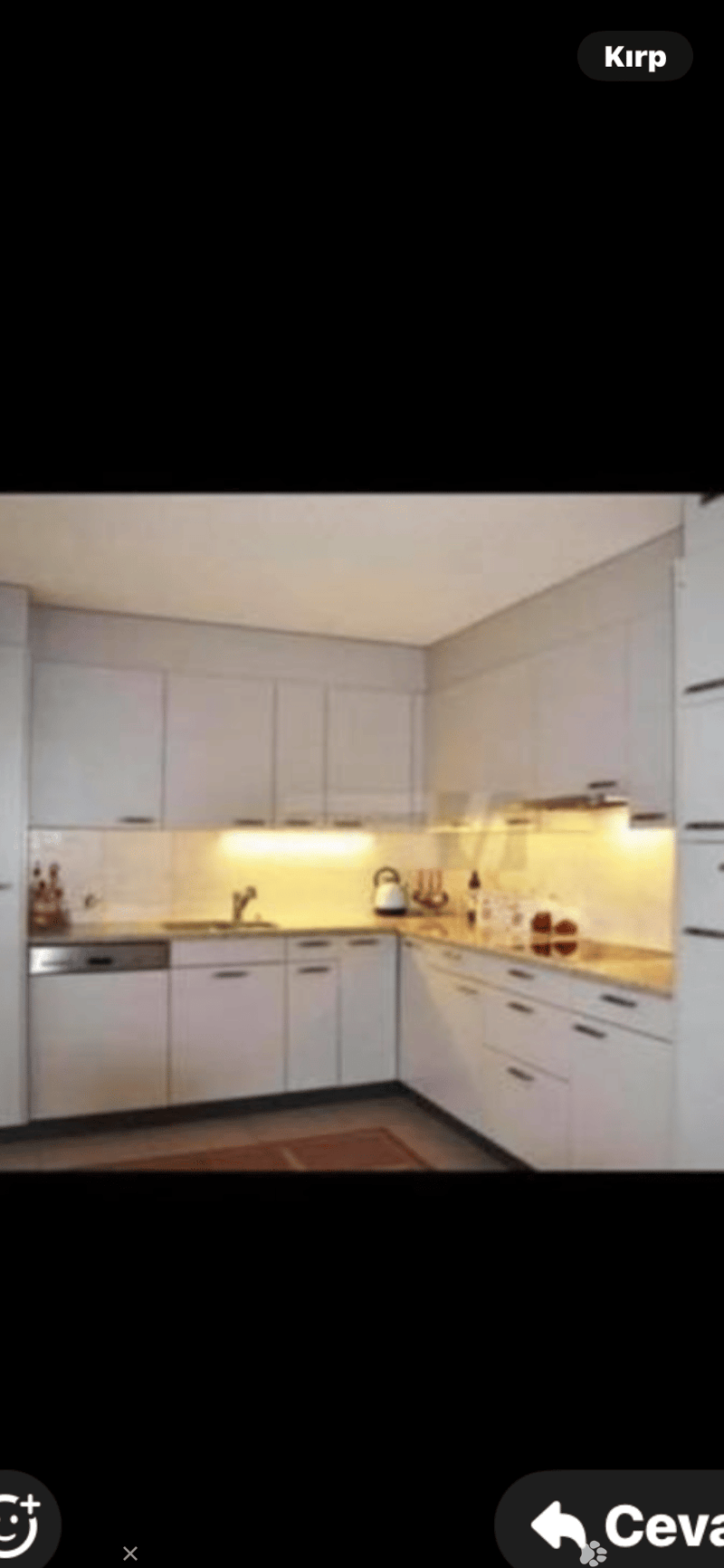 Modern kitchen with white cabinets, a sink, a dishwasher, and various kitchen utensils on the counter.
