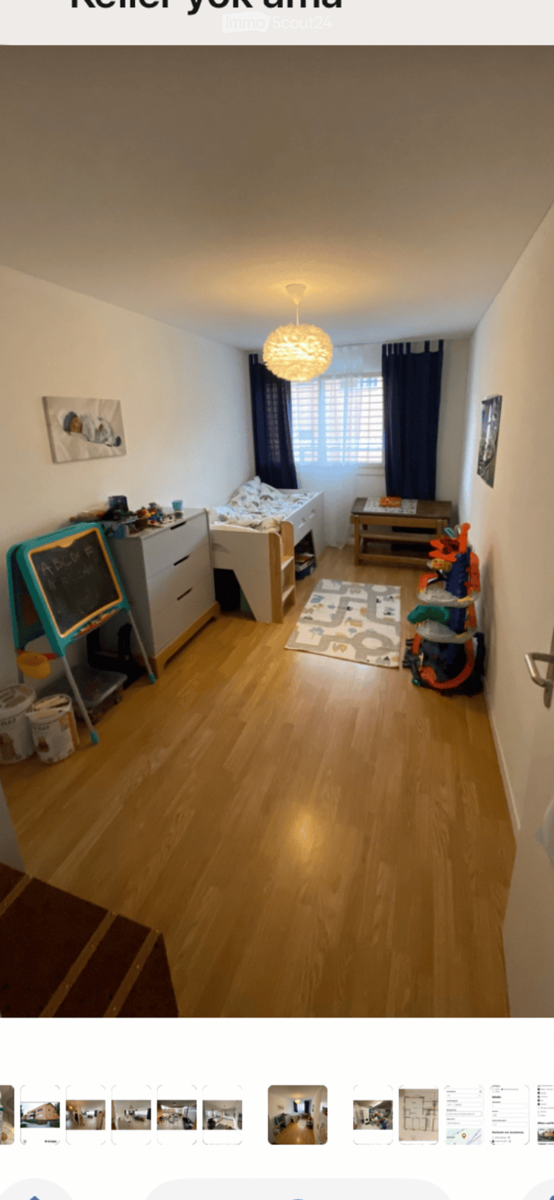 Cozy children's bedroom with wooden flooring, a small bed, nightstand, chair, and various toys.