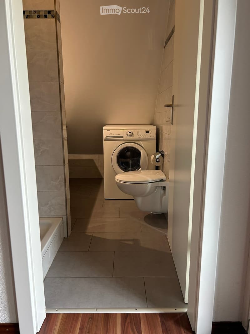 small bathroom with tile flooring, compact toilet, washing machine