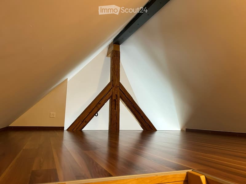 wooden support beam, hardwood floors, sloped ceiling