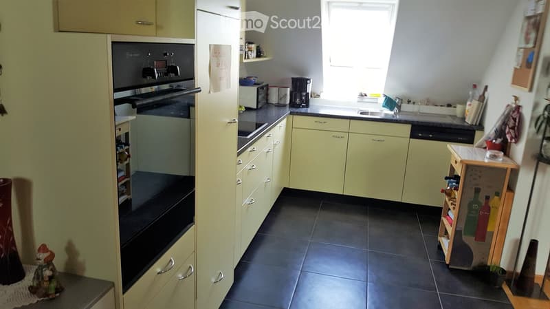 white cabinets, black countertops, stainless steel sink, oven, microwave, dishwasher, coffee machine, refrigerator