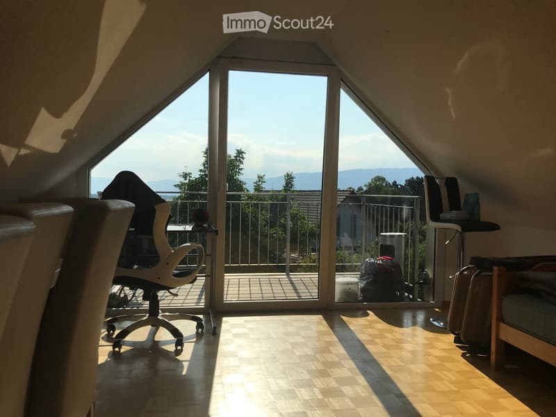 Slanted ceiling, chair, table, desk, glass door, balcony, hardwood floor, view
