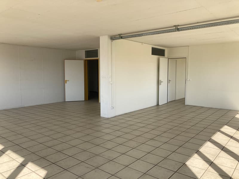 empty room with white tiles and open doors