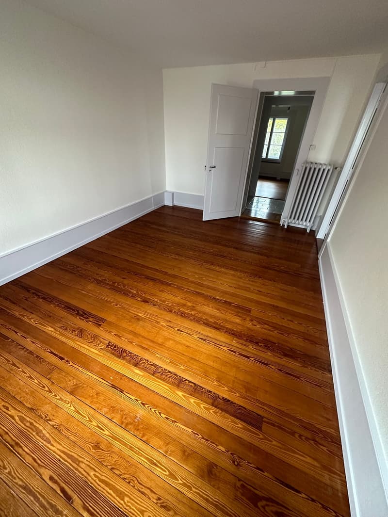 empty room, hardwood floor, white walls, white door, window, radiator