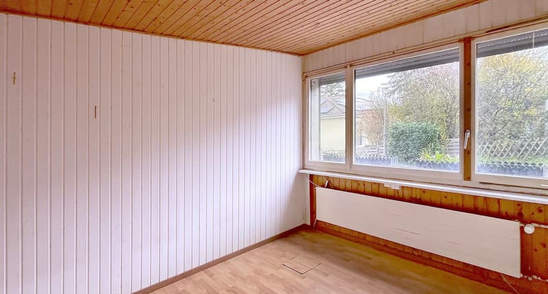 empty room with white wooden wall, brown wooden ceiling, wooden floor, white heater, 2 large windows with view