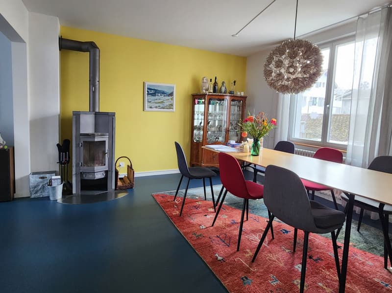 yellow wall, fireplace, dining table, chairs, cabinet, flowers, chandelier