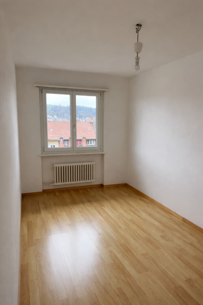 empty room, wooden floor, white walls, large window, radiator, ceiling lamp