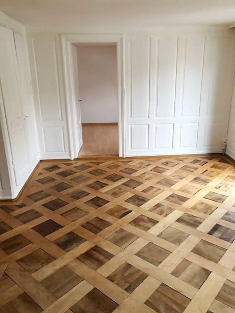 empty room, wooden parquet floor, white walls, wooden door, wooden flooring
