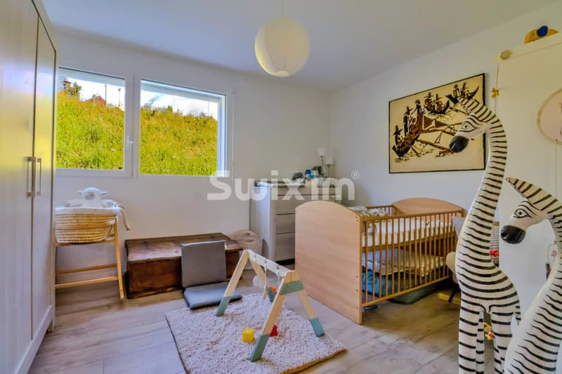 Chambre lumineuse avec un lit bébé, une aire de jeux pour enfants et une décoration moderne.